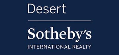 A blue sign with white text reads "Desert Sotheby's INTERNATIONAL REALTY." Thin horizontal white lines separate the words "Desert," "Sotheby's," and "INTERNATIONAL REALTY." This elegant design perfectly matches the upscale vibe of Palm Springs.