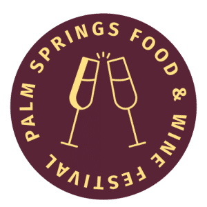 cropped-Untitled-6.png A circular logo with a maroon background spotlights two clinking champagne glasses in the center. The surrounding text reads "Palm Springs Food & Wine Festival" in uppercase, styled in a circular pattern, celebrating fine wine and culinary artistry.